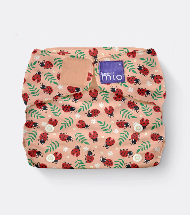 Patterned diaper with ladybug design on a peach background